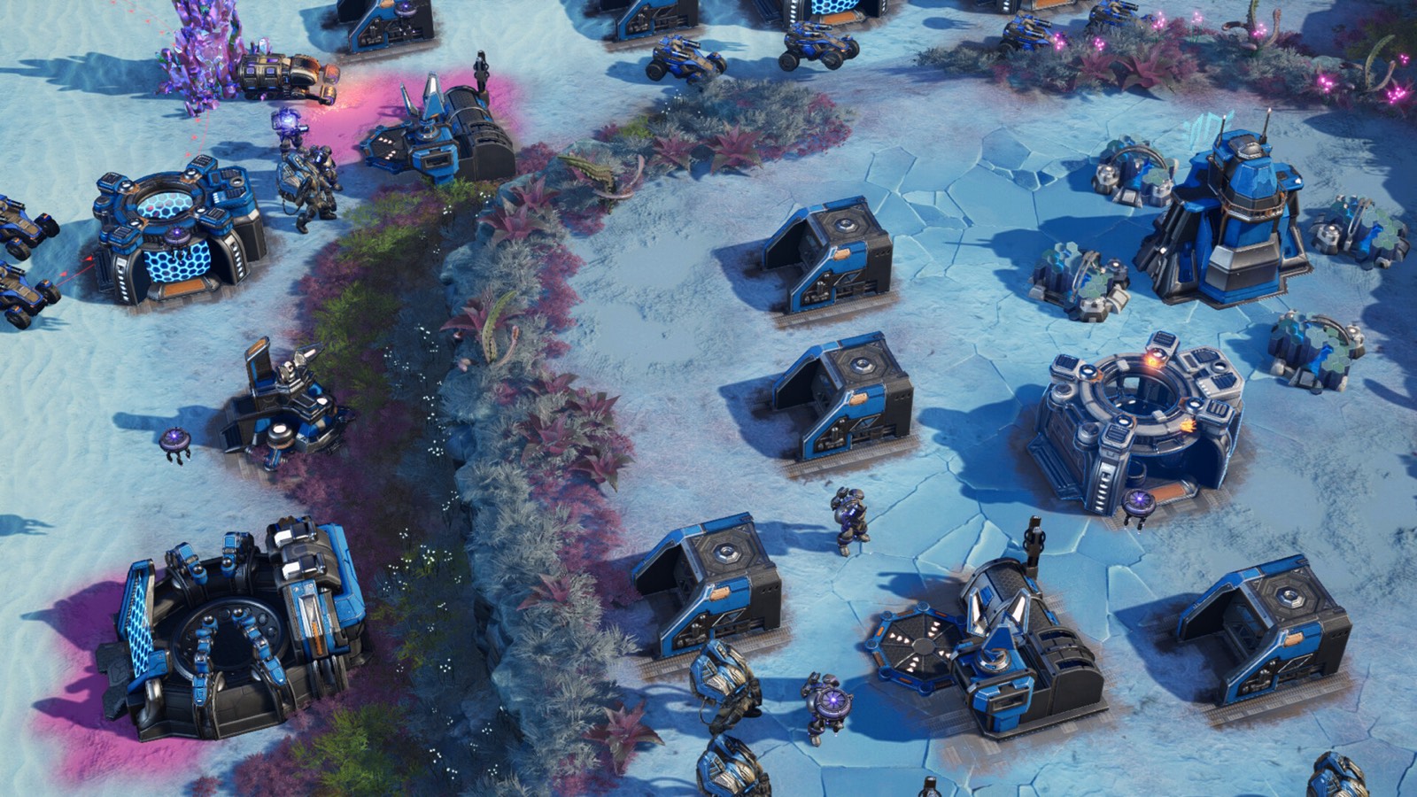 An established base with production structures laid out across pale terrain